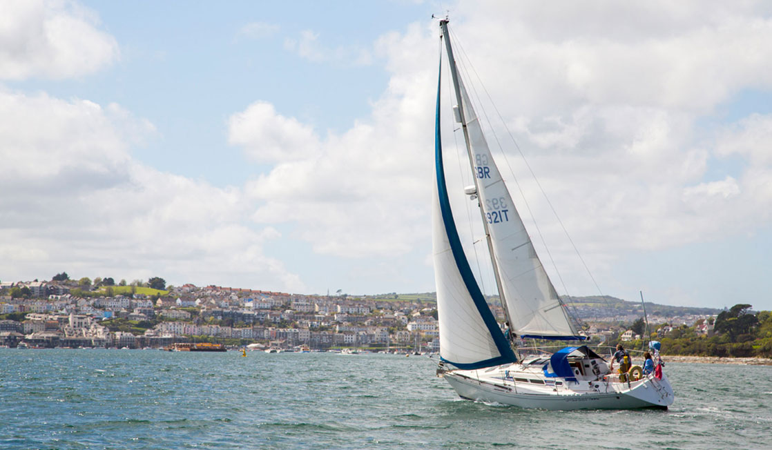 A yacht sailing across Falmouth Bay
