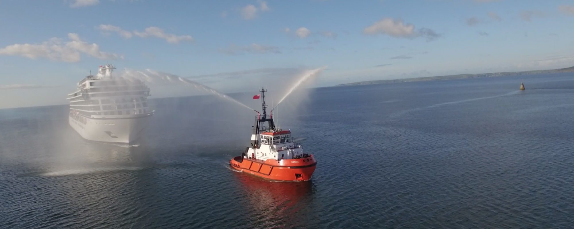 Cruise liner being escorted by fire tug