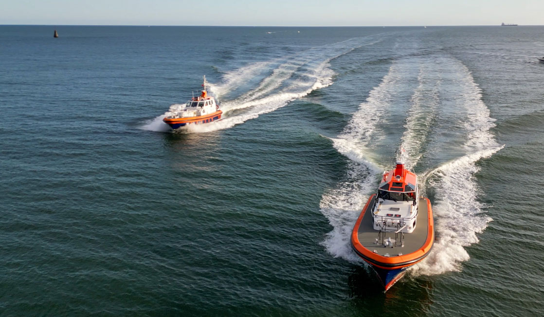 Two pilot boats powering towards the viewer