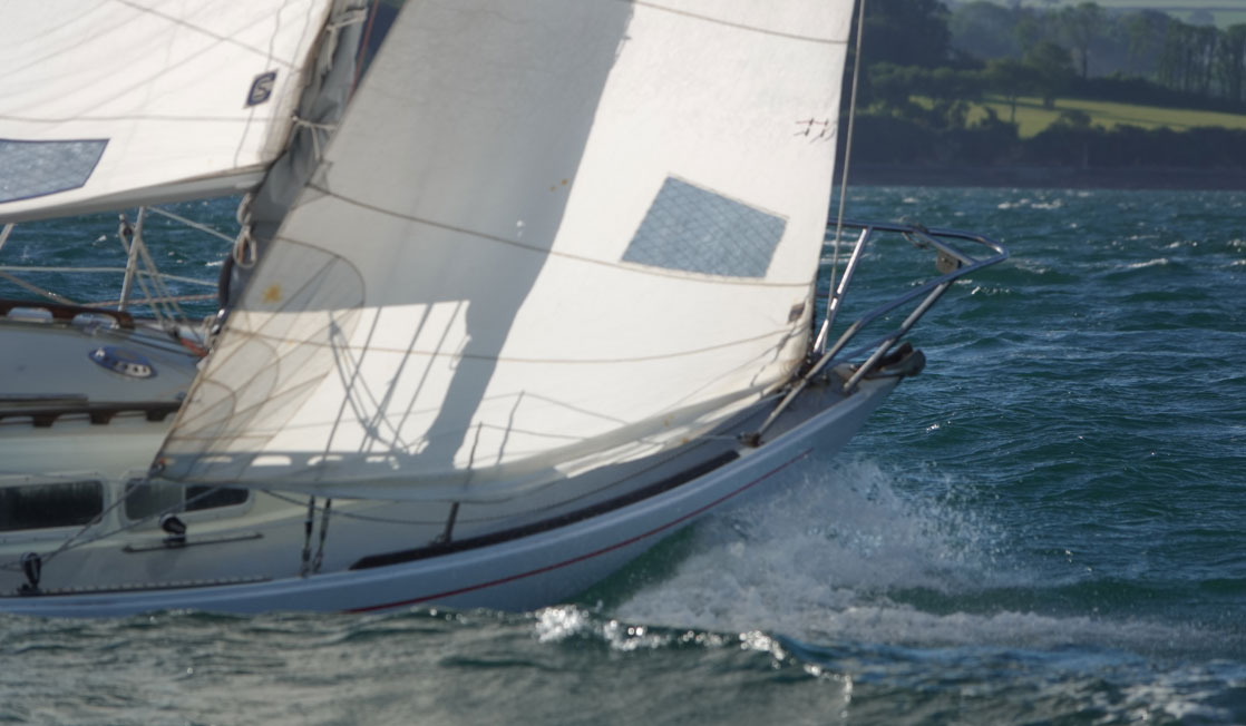 Sail boat cutting through choppy water